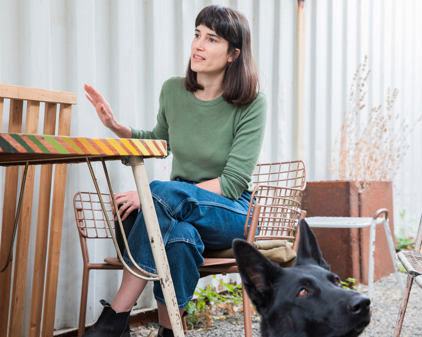 Marie Glusenkamp Perez talks about her work at Dean's Car Care, INC. in Portland alongside her canine companion Uma Furman on Thursday.