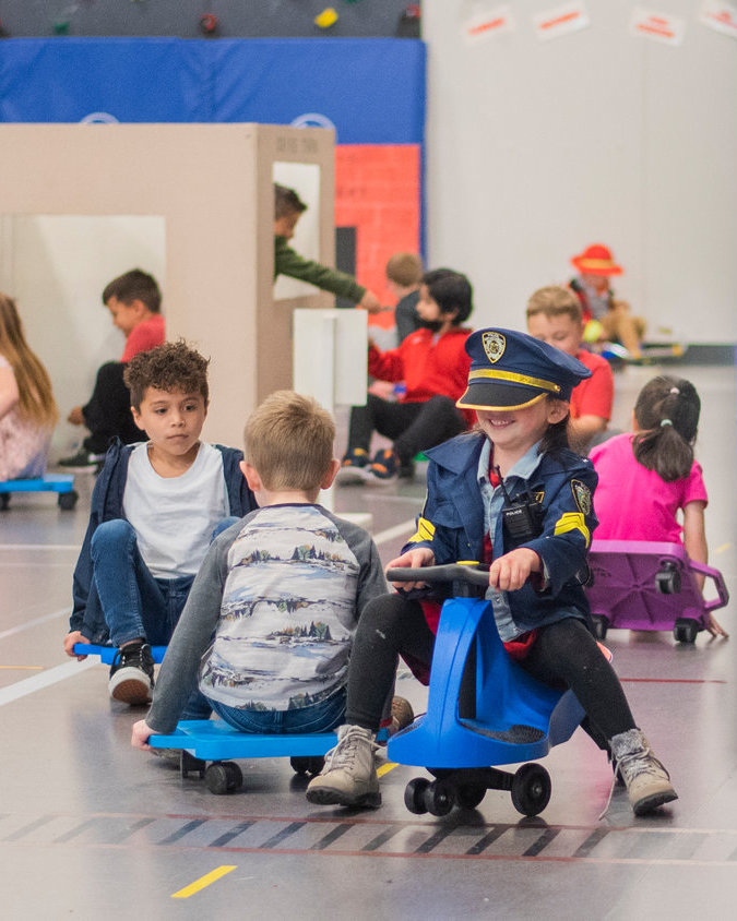 Students in Mrs. McVay and Mrs. Cole’s kindergarten classes ride scooters at James W. Lintott Elementary School.