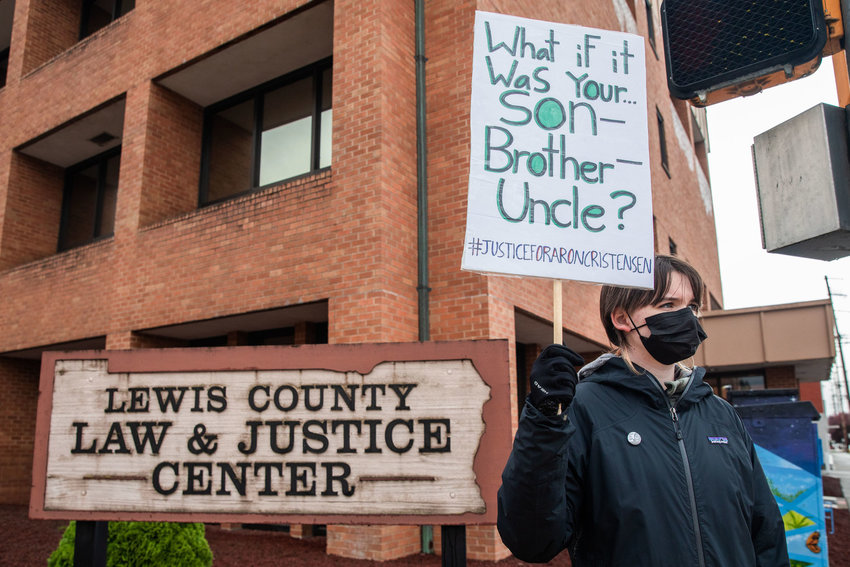 Demonstrators hold signs outside the Lewis County Law and Justice Center while demanding justice for Aron Christensen and his dog Buzzo in Chehalis last November.