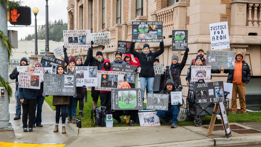 Friends of Aron Christensen hold signs outside the Lewis County Courthouse while demanding justice in Chehalis in November 2022.