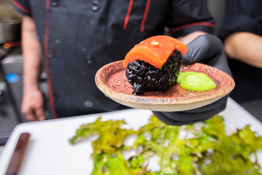 Chef Jim Wheeler shows off vegan nigiri made with black rice and marinated watermelon along with a house-made wasabi sauce at the Juice Box in Centralia in May.