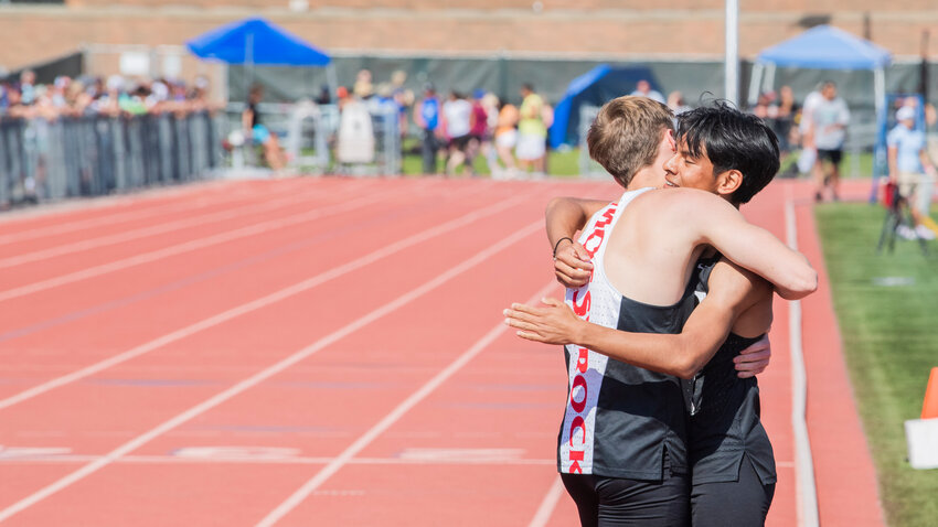 Mossyrock’s Christian Paz Tapia and Matt Cooper hug after taking fourth and first respectively in the 800 meter run at Zaepfel Stadium in Yakima on Saturday.