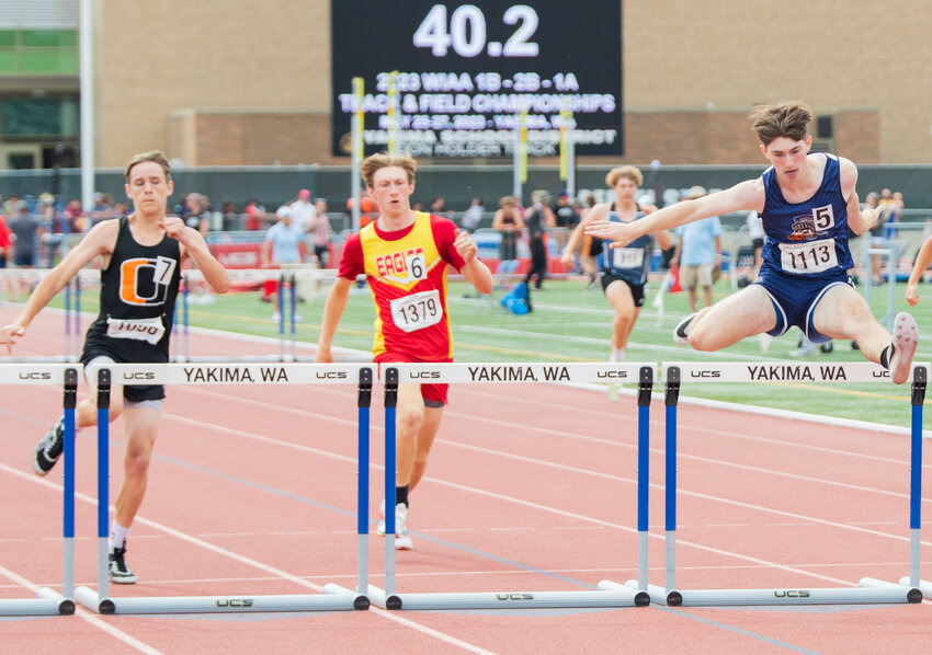 Pe Ell’s Carter Phelps flies over a hurdle to earn second in the 300 meter hurdle event — his second silver medal of the day — at the State track and field meet in Yakima on Saturday, May 27.