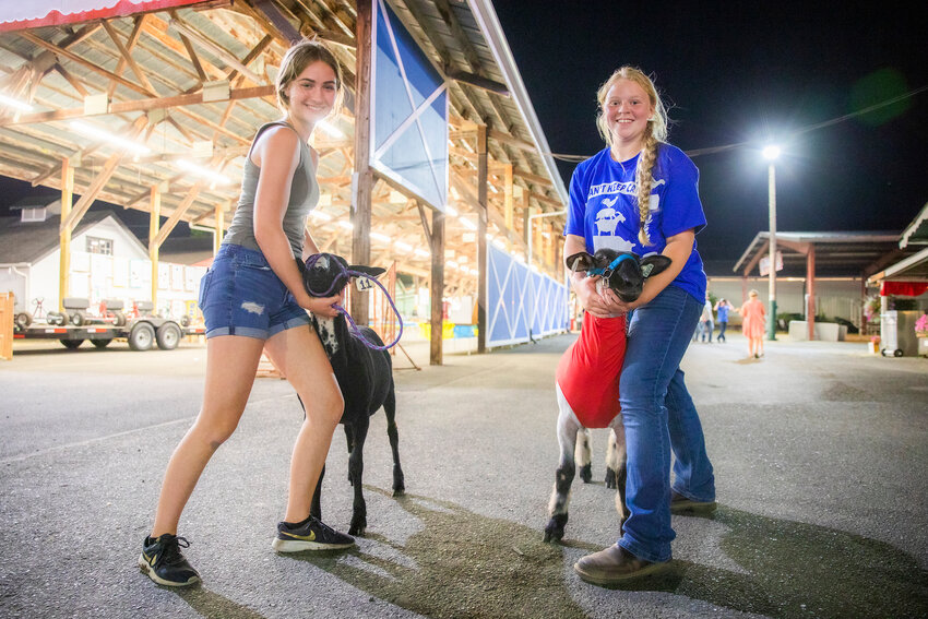 Haley Gallagher and Deseree Abrams smile and hold their sheep Juan and Shadow at the Southwest Washington Fairgrounds in 2022.