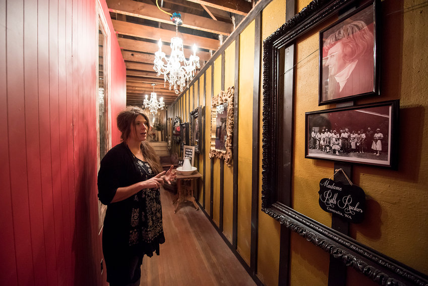 FILE PHOTO &mdash; Holly Phelps, owner of the Shady Lady in downtown Centralia, stands in the narrow hallway adorned with pictures of Madame Ruth Rucker, who ran a brothel in Centralia in the early 20th century, while giving a tour of her new Bordello Museum.
