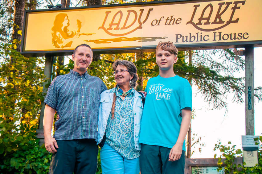 From left to right, Tom Rebecca and Tyler Pogue pose for a photo in front of the Lady of the Lake sign Thursday afternoon near Offut Lake in Tenino.