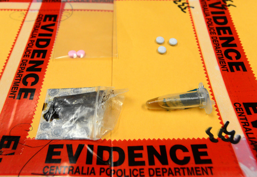 FILE PHOTO &mdash; Oxycodone pills, top, tar heroin, bottom left, and liquid heroin, is seen in the evidence department of the Centralia Police Department in this file photo.