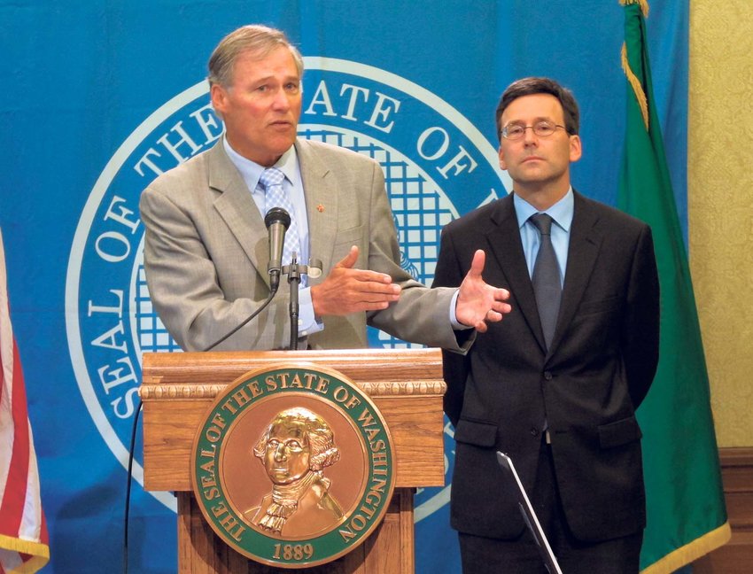 Washington state Gov. Jay Inslee, left, is joined by state Attorney General Bob Ferguson as he talks to the media in Olympia, Wash. about the federal government's announcement that it will not sue to stop Washington and Colorado from taxing and regulating recreational marijuana for adults, on Thursday, Aug. 29, 2013.