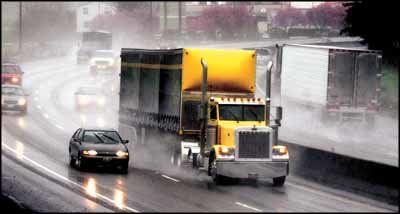 Cars and trucks create large sprays of water as they travel along Interstate 5 in this file photo.