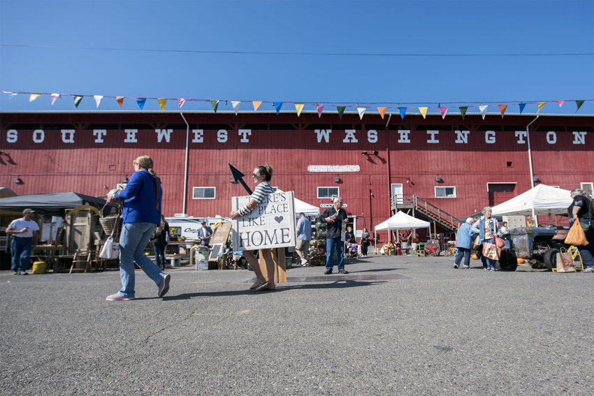 Shoppers walk across the Southwest Washington Fairgrounds carrying a variety of antiques they purchased at the Country Chicks Fall Fair in Chehalis in this 2016 file photo.