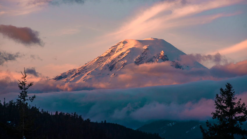 FILE PHOTO &mdash; Clouds surround Mount Rainier at sunset.