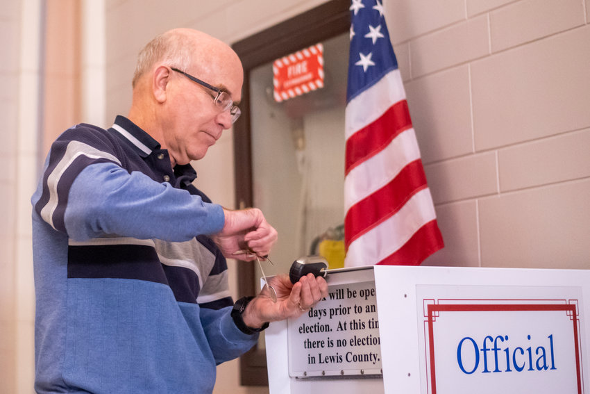 FILE PHOTO &mdash;&nbsp;Lewis County Auditor Larry Grove locks up an Official Ballot Box at the Lewis County Courthouse in Chehalis.