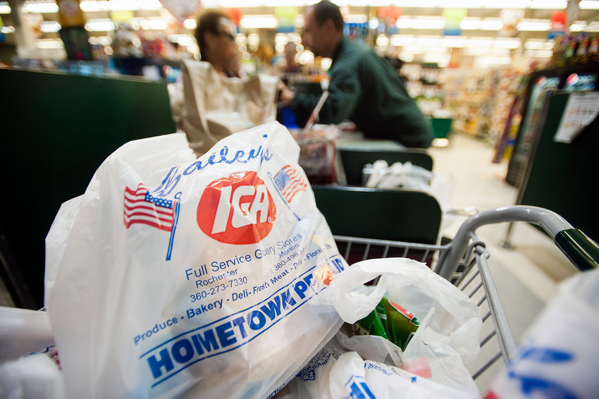 A cart full of plastic bags filled with groceries waits to be taken out to the parking lot at Bailey's IGA in Rochester in this Chronicle file photo.