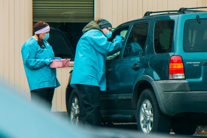 FILE PHOTO &mdash; Medical personnel at Valley View Health Center examine a patient at a drive-up COVID-19 testing site.