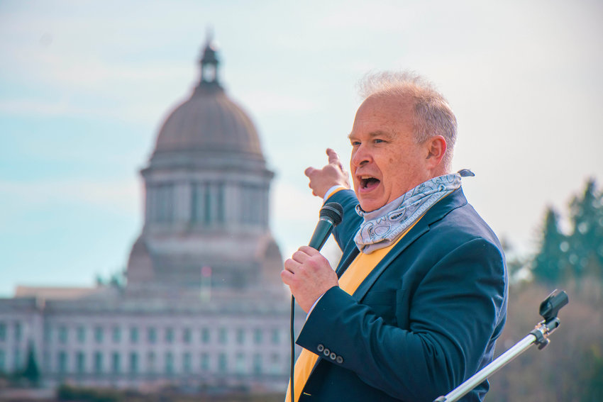 FILE PHOTO &mdash; State Rep. Jim Walsh points to the Washington State Capitol during a rally in support of bringing back in-person schooling near Capitol Lake.