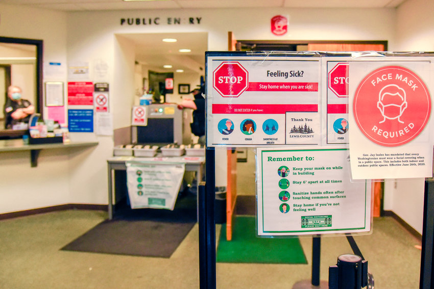 Various signs remind visitors that face masks are required before entering a security check inside the Lewis County Law and Justice Center on Thursday.