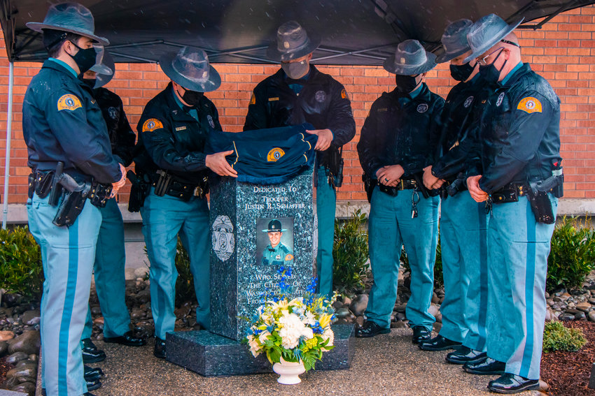 Troopers unveil a monument during a dedication ceremony Wednesday morning in Chehalis for Justin R. Schaffer, who was killed in the line of duty while attempting to deploy spike strips in March 2020.