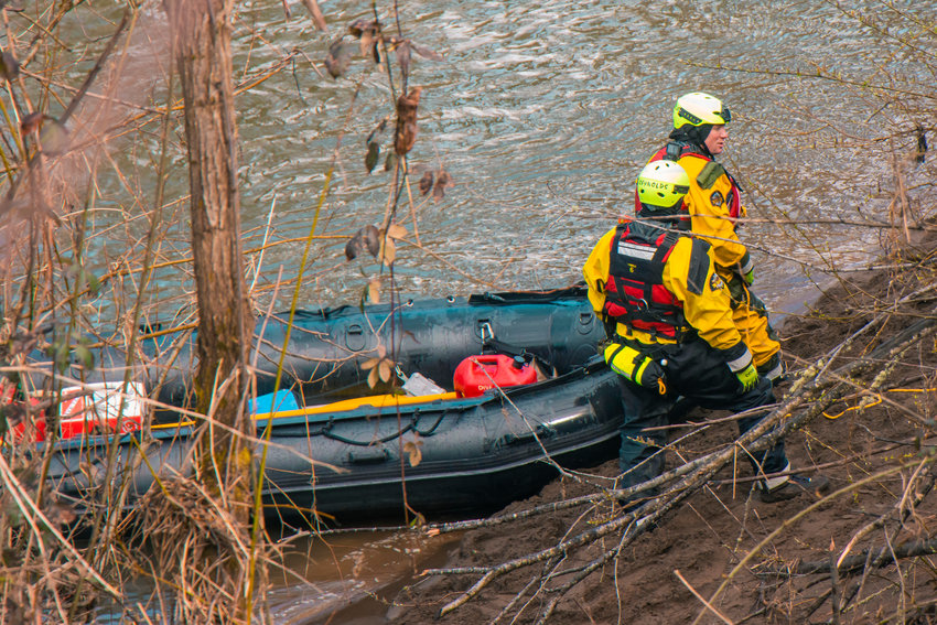 FILE PHOTO &mdash; Members of the Thurston County Sheriff Dive and Rescue crew stand on the bank of the Chehalis River during a search for missing teen Zach Hines-Rager in Adna. The Centralia teen died after jumping into the cold water.