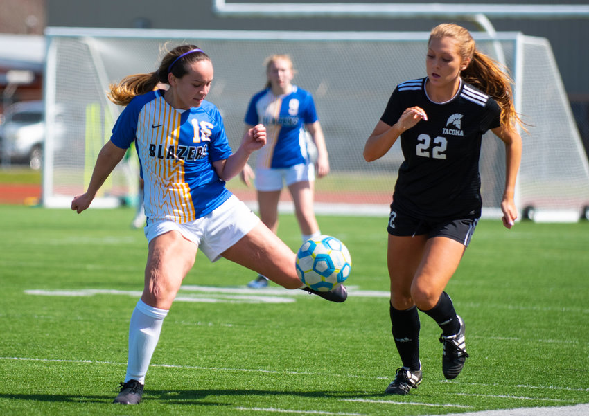 Centralia College sophomore Alexis Thompson (16) boots the bal against a Tacoma forward on Tuesday at Tiger Stadium.