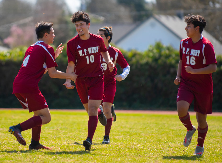 FILE PHOTO - W.F. West senior forward Antheny Mendez (10) is congratulated after scoring a goal in the opening 24 seconds of the Bearcats' home match against Rochester on Tuesday.