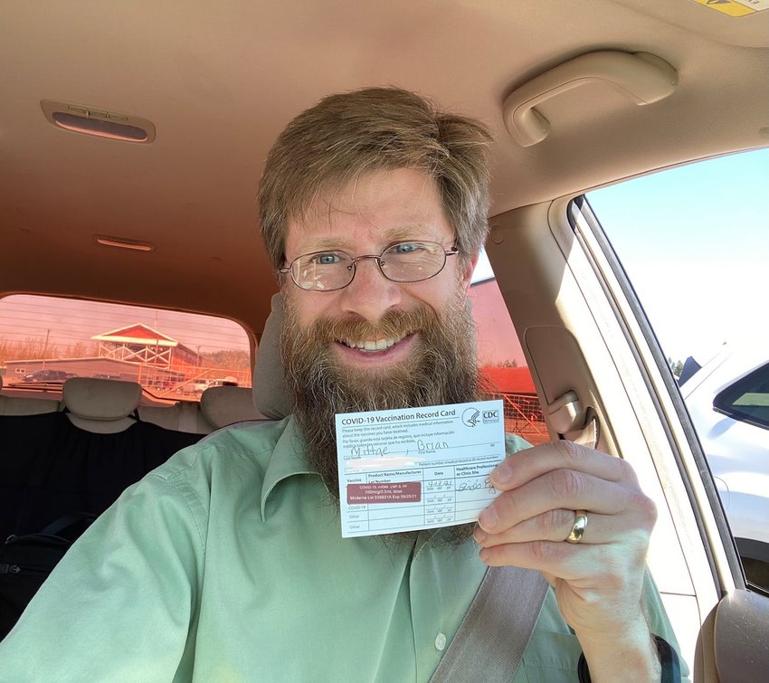 Brian Mittge shows off his vaccination card.