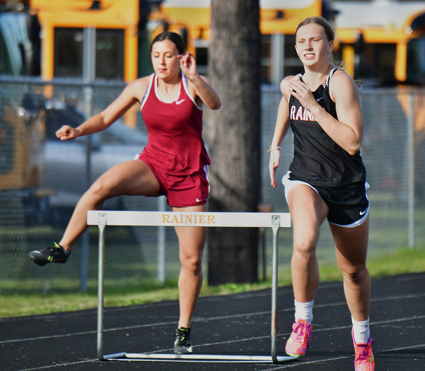Rainier High School&rsquo;s Kaeley Schultz, right, competes in the 300-meter hurdles on Thursday, April 29, during the WIAA District 4 Track &amp; Field Championships at Rainier High School.