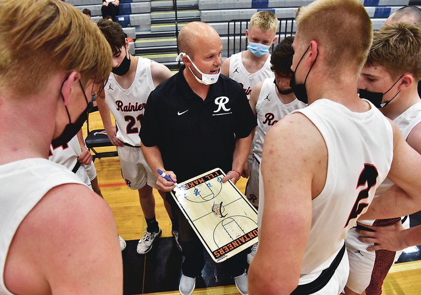 Jeremy Landram, Rainier High School head boys basketball coach, discusses strategy with his team during a timeout in Rainier&rsquo;s practice game against Yelm High School on Saturday, May 1, in Rainier.