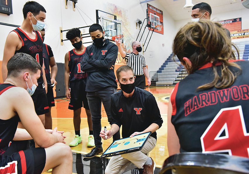 Dave Wasankari, Yelm High School head boys basketball coach, discusses strategy with his team during a timeout in Yelm&rsquo;s practice game against Rainier High School on Saturday, May 1, in Rainier.