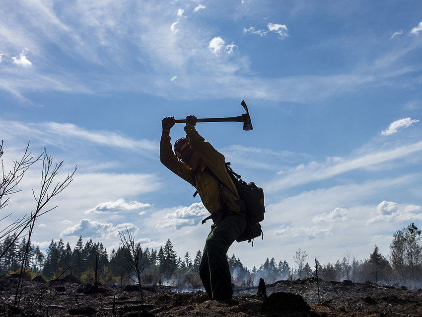 FILE PHOTO&mdash; Ryan Whitmore, a member of the PatRick Crew, a private group based out of Redmond, Ore., digs up a hotspot at the Gish Road fire on Monday, Aug. 10, 2015 near Onalaska.