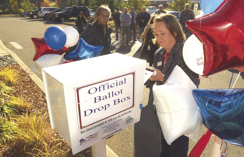 2018 FILE PHOTO &mdash; Thurston County Auditor Mary Hall officially unlocks a new ballot box installed outside the Nisqually Administration Building.