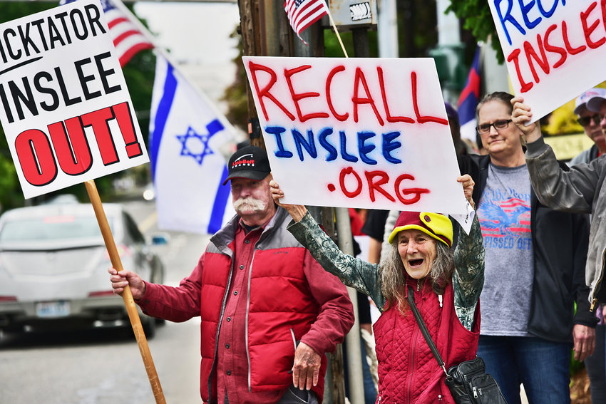Yelm resident Bronwen Dickinson, middle right with red vest, shouts with glee at honking cars on Union Avenue during a gathering in Olympia on Monday, May 17, at the Secretary of State&rsquo;s Office to file a petition for recall against Washington Gov. Jay Inslee. Dickinson was among about 100 people to attend the rally.