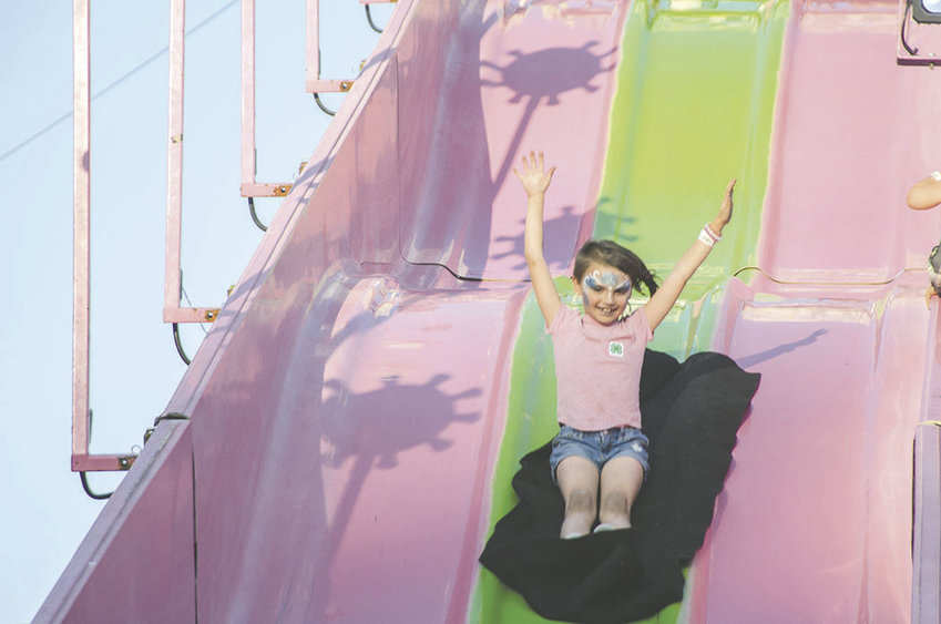 Children slide down a super slide at the Thurston County Fair in 2018.