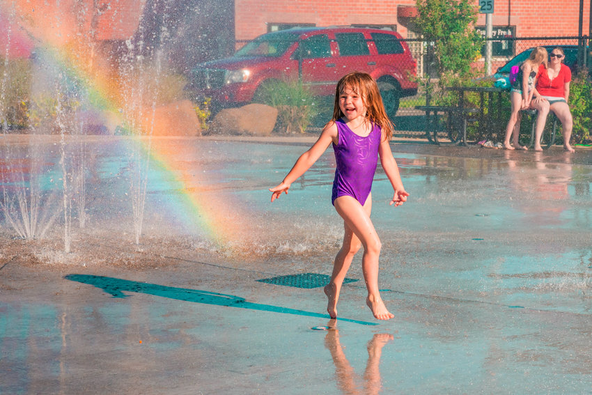 Emma Newkirk, 4, smiles and plays in the newly reopened splash pad last month.