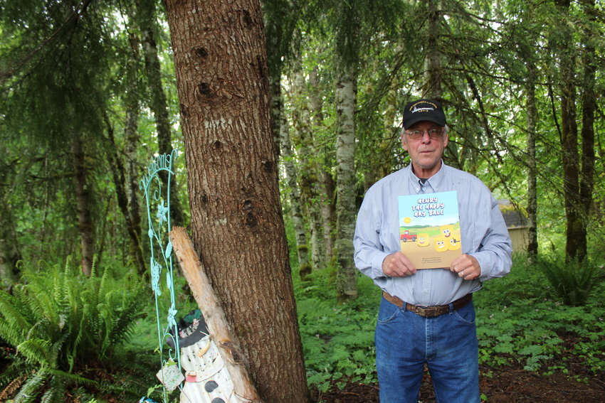 Bill Goodwin poses for a photo with a copy of his new book, &ldquo;Henry the Happy Hay Bale.&rdquo;