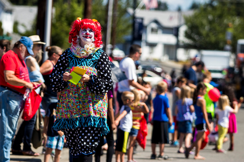 A woman dressed as a clown smiles as she walks down the sidewalk during the annual Funtime Parade in 2018.