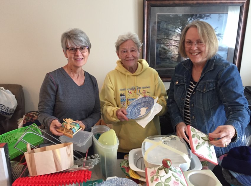 Neighbors of Colleen Hoss help organize items for an upcoming yard sale. Hoss will donate profits from the fundraiser to the Alzheimer&rsquo;s Association.