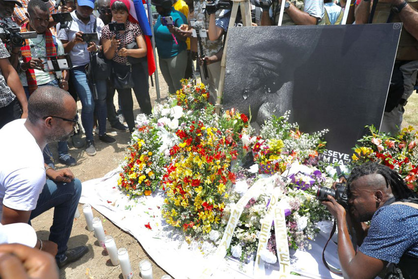 People pay their respects outside of the Presidential Palace in Port-au-Prince on July 14, 2021, in the wake of Haitian President Jovenel Moise's assassination that occurred early on July 7, 2021.