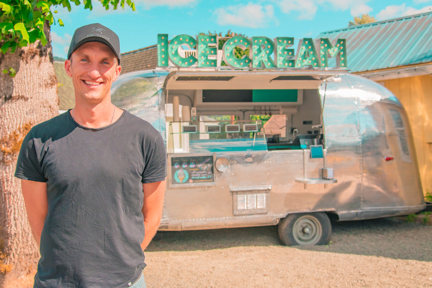 Sean Schwalbe smiles and poses for a photo in front of his Ice Cream Airstream Wednesday in Packwood.
