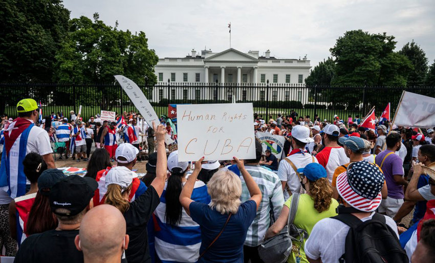 Protesters hold up signs during a demonstration in front of the White House in Washington DC, on July 25, 2021. - Rallies are taking place around the world as Cuba endures its worst economic crisis in 30 years, with chronic shortages of electricity, food and medicine amid an uptick in Covid-19 cases. About 60 Cubans have been prosecuted so far for participating in unprecedented demonstrations against the Cuban government earlier this month, a senior official said on July 24, 2021. (Andrew Caballero-Reynolds/AFP via Getty Images/TNS)