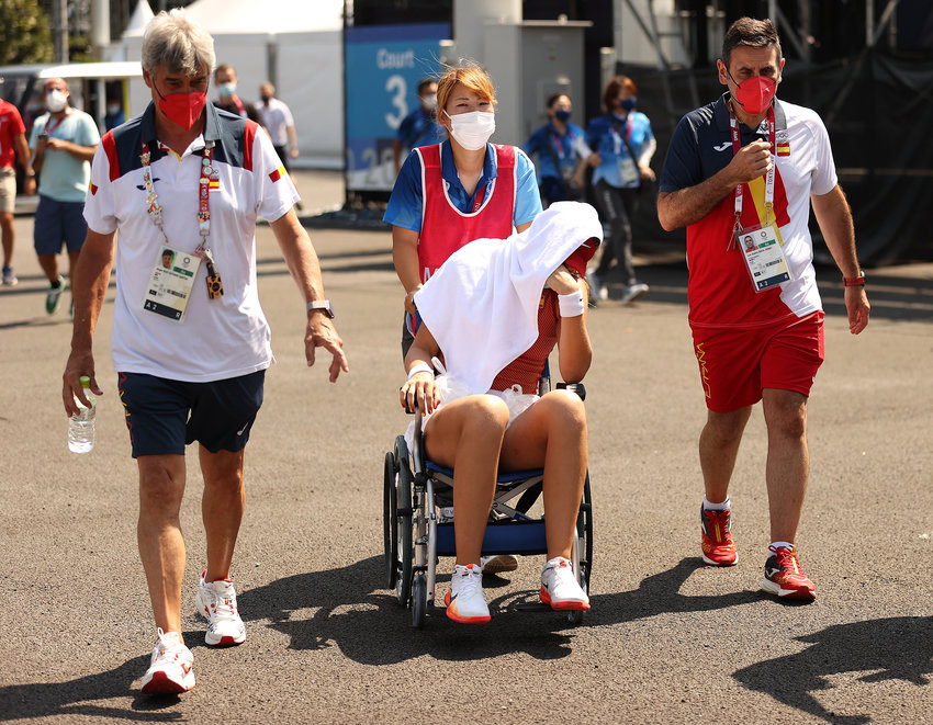 Paula Badosa of Team Spain is helped away from the court in a wheelchair after having to retire from her Women's Singles Quarterfinal match against Marketa Vondrousova of Team Czech Republic on day five of the Tokyo 2020 Olympic Games at Ariake Tennis Park on July 28, 2021 in Tokyo, Japan.