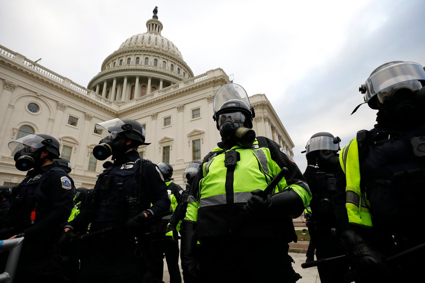 Police officers stand guard while supporters of Donald Trump riot on the steps of the U.S. Capitol on Capitol Hill in Washington, D.C., on Wednesday, Jan. 6, 2021. (Yuri Gripas/Abaca Press/TNS)