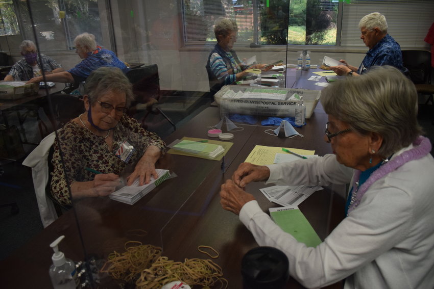 Theresa Gantzkow, left, and Arlene Carlson check ballots at the Clark County Elections office on Aug. 3.