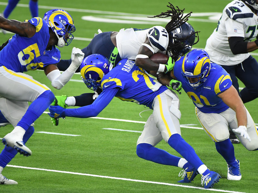 Seahawks running back Alex Collins flies over Rams defenders during a regular-season game on Nov. 15, 2020 in Inglewood, California.