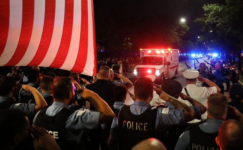 Chicago police officers salute as the ambulance carrying the body of Officer Ella French arrives at the Cook County medical examiner in the early morning hours of Aug. 8, 2021. (Chris Sweda/Chicago Tribune/TNS)