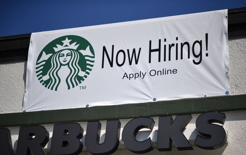 A &quot;Now Hiring&quot; sign is displayed outside a Starbucks drive-thru coffee shop in Glendale, California, July 7, 2021.  (Robyn Beck/AFP via Getty Images/TNS)