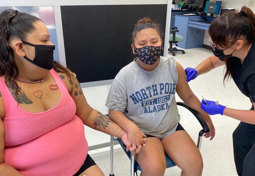 Summer Ariwite holds hands with her niece, Kaycee Moss, who recently turned 12, old enough to be vaccinated for COVID-19 by Samantha Allen, a public-health nurse at the Fort Belknap Indian Reservation. (Richard Read/Los Angeles Times/TNS)