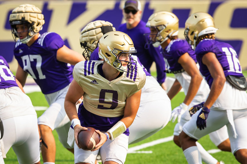 Huskies quarterback Dylan Morris looks for the hand-off as the University of Washington Huskies practice during fall camp at Husky Stadium in Seattle Saturday Aug. 14, 2021.