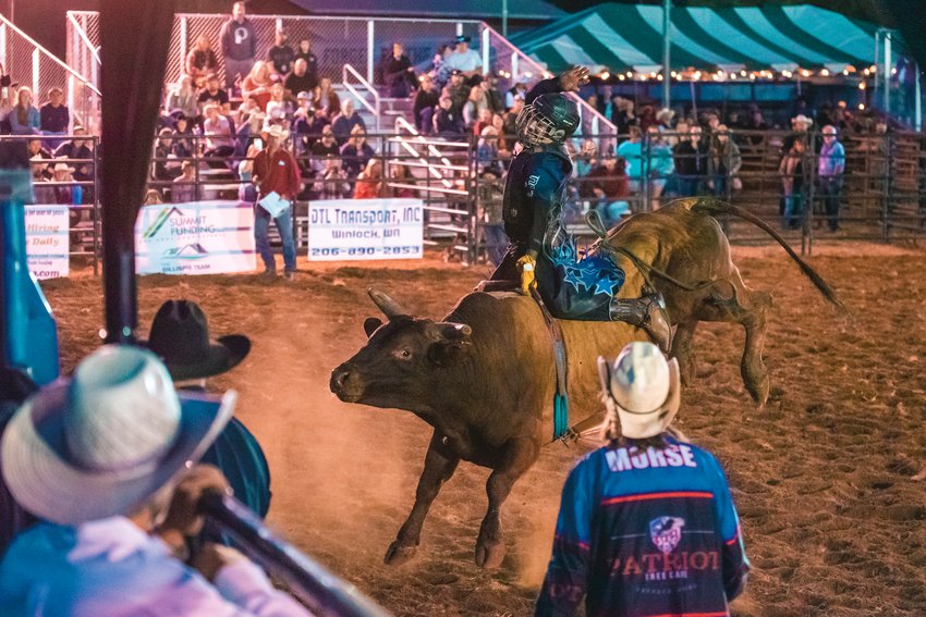 A bull rider tries to hang on as he is bucked during the Saturday night rodeo at the Southwest Washington Fairgrounds in Centralia.