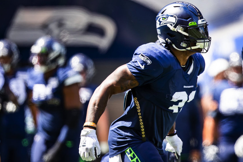 Running back Chris Carson warms up before the Seahawks play a mock game at Lumen Field in Seattle, Aug. 8, 2021.