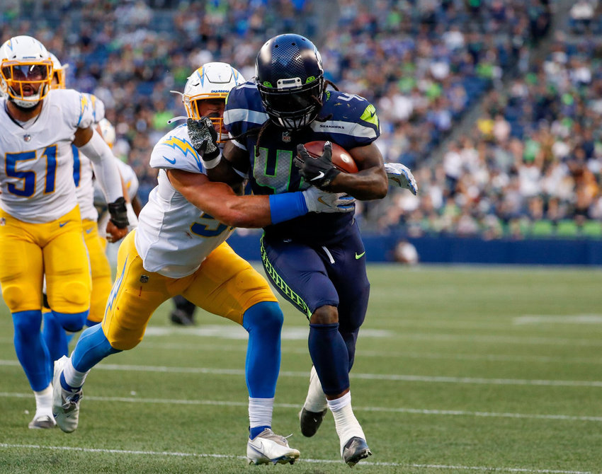 Seattle Seahawks running back Alex Collins tries to push past Los Angeles Chargers linebacker Cole Christiansen during the first quarter Saturday.
